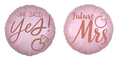 The Anagram/MD 18" Blush Wedding Foil Balloons are round and pink, featuring rose gold text. One says "SHE SAID Yes!" with a diamond ring graphic; the other reads "Future Mrs," also with a diamond ring graphic.