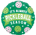 The 18" Pickleball Foil Balloon by Anagram/MD is round and green, featuring white and pink pickleballs with “It’s Always Pickleball Season” in bold white and yellow letters.