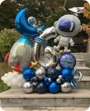 a sixth birthday space display of rocket ships, the moon, an astronaut in silver and blues