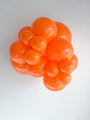 A cluster of Tuftex TT-260's Standard Orange Twisting Animal Latex Balloons floats together against a plain white background.