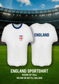 Two 24″ white and blue metallic sports shirt-shaped foil balloons by Oaktree, shown front and back on a soccer field. The front features the England crest; the back displays “ENGLAND.” Text below reads: 24″ Shape Sports Shirt England White/Blue Metallic Oaktree Brand Foil Balloon, suitable for helium or air fill.