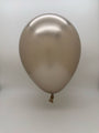 A single Balloonia 260BN Brilliant Beige Professional Line twisting latex balloon (from a 50-pack) floats against a plain, light background. The knot is visible at the bottom, and its smooth, shiny surface reflects light.