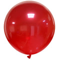 A 36″ Cattex Brand Crystal Red Latex Balloon is fully inflated and floating indoors, its shiny surface reflecting light from the ceiling above.
