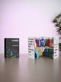 A closed 2026 Kalisan Latex Balloons Black Color Book Portfolio by Kalisan stands on the left, while an open one on the right reveals organized multicolored balloons attached to labeled panels. A leafy plant appears partially on the right.