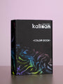 A black portfolio titled "2026 Kalisan Latex Balloons Black Color Book Portfolio" by Kalisan stands upright on a smooth surface with a silver metallic logo and a vibrant, marble-like pattern near the bottom against a pale pink background.