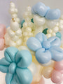 A close-up of floral balloon clusters crafted from Gemar’s 260G Latex Balloons in Marshmallow Powder Pink, with delicate shapes twisted against a light background.