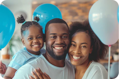 A smiling man, woman, and child with balloons